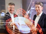 Continental CEO Elmar Degenhart and CFO Wolfgang Schäfer show the digital protection shield of a car.
