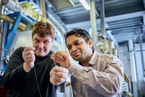  Scientist Pavan Manvi from RWTH Aachen University (right) and Covestro researcher Dr. Jochen Norwig holding a synthetic fiber prototype made from CO2.